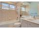 Bright bathroom features tile walls, single sink vanity, and a bathtub with showerhead at 1616 Palmetto Palm Way, North Port, FL 34288