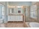 Bright bathroom with double vanity, a tiled walk-in shower, and an elegant soaker tub at 1616 Palmetto Palm Way, North Port, FL 34288