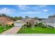 Inviting yellow home with a two-car garage, lush landscaping, and a well-manicured lawn at 1616 Palmetto Palm Way, North Port, FL 34288