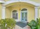 Elegant entryway featuring a striking blue double door, arched transom window, and well-lit portico at 1616 Palmetto Palm Way, North Port, FL 34288