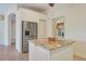 Kitchen island, stainless steel refrigerator, and view into the dining room and beyond at 1616 Palmetto Palm Way, North Port, FL 34288