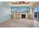 Bright living room featuring fireplace with built-in shelving, large windows, and decorative ceiling fan at 1616 Palmetto Palm Way, North Port, FL 34288