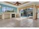 Living room with tile floors, fireplace, built-in shelving, and sliding glass doors leading to the screened-in pool area at 1616 Palmetto Palm Way, North Port, FL 34288