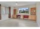 Bright office area with custom wood cabinets, desk, and views of a private treed backyard at 1616 Palmetto Palm Way, North Port, FL 34288