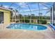 Screened-in pool with well maintained deck area surrounded by privacy landscaping at 1616 Palmetto Palm Way, North Port, FL 34288
