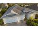 Aerial view of well-maintained home, lush landscaping, three-car garage, and peaceful pond at 17917 Wayside Bnd, Punta Gorda, FL 33982