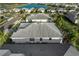 An aerial view shows a home with a gray roof surrounded by lush landscaping and a community lake at 17917 Wayside Bnd, Punta Gorda, FL 33982