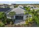 Back aerial view shows screened lanai, brick patio, mature palms, and meticulously landscaped surroundings at 17917 Wayside Bnd, Punta Gorda, FL 33982