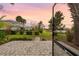 Landscaped backyard with brick patio, trimmed bushes, and view of a tranquil pond at 17917 Wayside Bnd, Punta Gorda, FL 33982