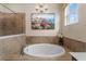 Soaking tub under a chandelier near walk-in shower with a view of artwork at 17917 Wayside Bnd, Punta Gorda, FL 33982