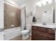 Cozy bathroom features a shower over tub, a toilet, and a dark wooden sink cabinet at 17917 Wayside Bnd, Punta Gorda, FL 33982