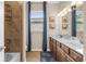 Modern bathroom featuring double sinks, blue curtains, and tiled shower over tub at 17917 Wayside Bnd, Punta Gorda, FL 33982