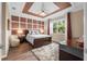 Beautiful bedroom featuring a decorative ceiling and accent wall, and a large window at 17917 Wayside Bnd, Punta Gorda, FL 33982