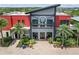 Modern building with red and gray accents, manicured landscaping, and palm trees creating a grand entrance at 17917 Wayside Bnd, Punta Gorda, FL 33982
