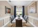 Dining area has modern chandelier, white table with seating for six, and blue window treatments at 17917 Wayside Bnd, Punta Gorda, FL 33982