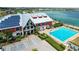 Aerial view of a complex featuring solar panels, a pool, and picturesque waterfront views at 17917 Wayside Bnd, Punta Gorda, FL 33982