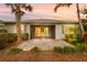 Home's back exterior with screened lanai, brick patio, trimmed bushes, and mature landscaping at 17917 Wayside Bnd, Punta Gorda, FL 33982