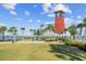 Scenic waterfront view featuring a decorative clock tower, green space, and palm trees at 17917 Wayside Bnd, Punta Gorda, FL 33982