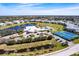Aerial view of community clubhouse, pool, tennis courts, and lush landscaping at 2081 Willow Hammock Cir # F101, Punta Gorda, FL 33983