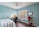 Cozy blue bedroom featuring a bed, desk with chair, and window with plantation shutters at 2081 Willow Hammock Cir # F101, Punta Gorda, FL 33983