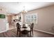 Dining area with a chandelier, glass table, four chairs, and white-shuttered windows, open to the kitchen at 2081 Willow Hammock Cir # F101, Punta Gorda, FL 33983