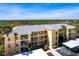 Bright condo building with yellow facade, multiple floors, and palm trees on a sunny day at 2081 Willow Hammock Cir # F101, Punta Gorda, FL 33983