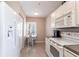 Bright kitchen featuring white appliances, cabinets, and tile flooring with a view into the breakfast nook at 2081 Willow Hammock Cir # F101, Punta Gorda, FL 33983