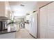Open kitchen with white appliances and cabinets, tile flooring, and view into the living and dining areas at 2081 Willow Hammock Cir # F101, Punta Gorda, FL 33983