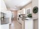 Bright kitchen with white cabinets, tile floor, and view of the dining area with natural light at 2081 Willow Hammock Cir # F101, Punta Gorda, FL 33983