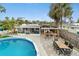 Relaxing backyard oasis with pool, screened patio, outdoor dining, and tropical landscaping at 23475 Harper Ave, Port Charlotte, FL 33980