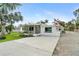 Quaint single-story home with manicured landscaping and a long concrete driveway at 23475 Harper Ave, Port Charlotte, FL 33980