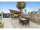 Backyard patio featuring an outdoor kitchen, dining area, and lush landscaping providing a private oasis at 23475 Harper Ave, Port Charlotte, FL 33980