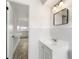 Bathroom view with white vanity and a view into the adjacent kitchen space at 23475 Harper Ave, Port Charlotte, FL 33980