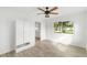 Bright bedroom featuring wood floors, built-in storage, and a window with backyard view at 23475 Harper Ave, Port Charlotte, FL 33980