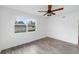 Bright bedroom featuring wood floors, a ceiling fan, and a large window at 23475 Harper Ave, Port Charlotte, FL 33980