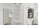Hallway featuring a built in shelving unit, wood-look floors, and access to additional rooms at 23475 Harper Ave, Port Charlotte, FL 33980