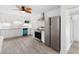 Updated kitchen boasts white cabinets, stainless steel appliances, and a stylish blue dishwasher at 23475 Harper Ave, Port Charlotte, FL 33980