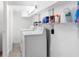 Clean laundry room with modern washer and dryer and ample shelving for storage at 23475 Harper Ave, Port Charlotte, FL 33980