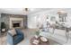 Staged spacious living room with a stone fireplace and wood-look flooring, great for entertaining at 23475 Harper Ave, Port Charlotte, FL 33980