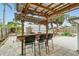 Outdoor bar and seating area with a wood-covered pergola and patio for enjoying the backyard at 23475 Harper Ave, Port Charlotte, FL 33980