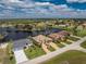 Aerial view of a cluster of homes with serene lake views in a tropical location at 24362 Peppercorn Rd, Punta Gorda, FL 33955
