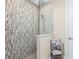 Modern bathroom featuring stylish tile shower, glass partition, handheld shower head, and convenient towel storage at 24362 Peppercorn Rd, Punta Gorda, FL 33955