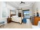 Elegant bedroom with a four-poster bed, shuttered windows, and access to a screened patio and pool area at 24362 Peppercorn Rd, Punta Gorda, FL 33955