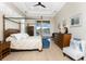 Serene bedroom featuring a four-poster bed and access to a screened patio overlooking the pool at 24362 Peppercorn Rd, Punta Gorda, FL 33955