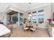 Dining area with lake views, featuring a round wooden table and access to the outdoor living space and pool at 24362 Peppercorn Rd, Punta Gorda, FL 33955