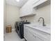 Bright laundry room with modern washer and dryer, white cabinets, and a sink with stylish faucet at 24362 Peppercorn Rd, Punta Gorda, FL 33955