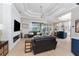 Open-concept living room with coffered ceilings, a modern fireplace, and lake views at 24362 Peppercorn Rd, Punta Gorda, FL 33955