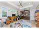 Comfortable living room with tray ceiling, ceiling fan, custom bookcase, fireplace, and plantation shutters at 24362 Peppercorn Rd, Punta Gorda, FL 33955