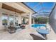 Expansive covered patio with ample seating, a pool, and a serene water view at 24362 Peppercorn Rd, Punta Gorda, FL 33955