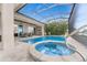 Luxurious pool and hot tub with a screened-in enclosure and inviting seating area at 24362 Peppercorn Rd, Punta Gorda, FL 33955